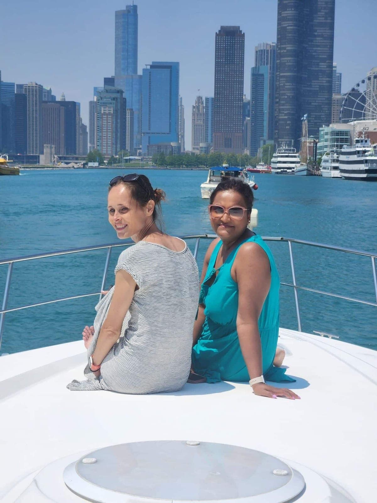 Two ISG teammates on a boat with the lake and skyline behind them