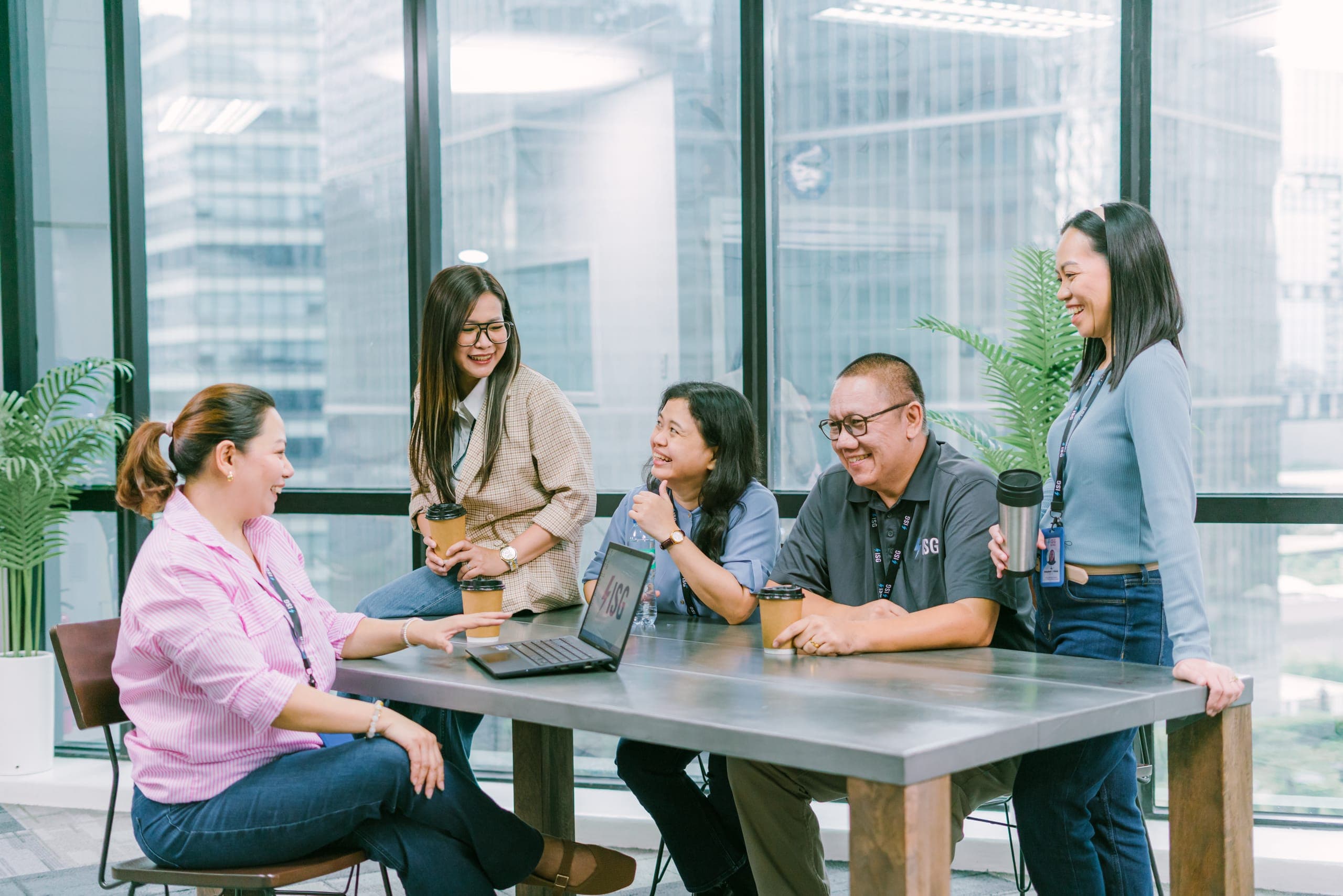ISG team collaborating in a boardroom overlooking the Manila skyline